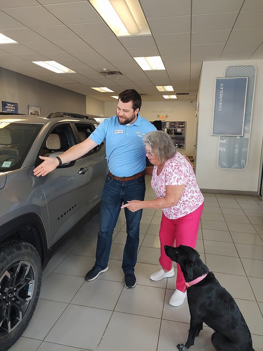 Sales associate showing cars to customers